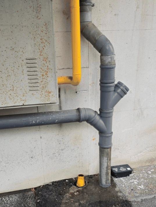 Bajantes de PVC gris nuevas instaladas en fachada exterior