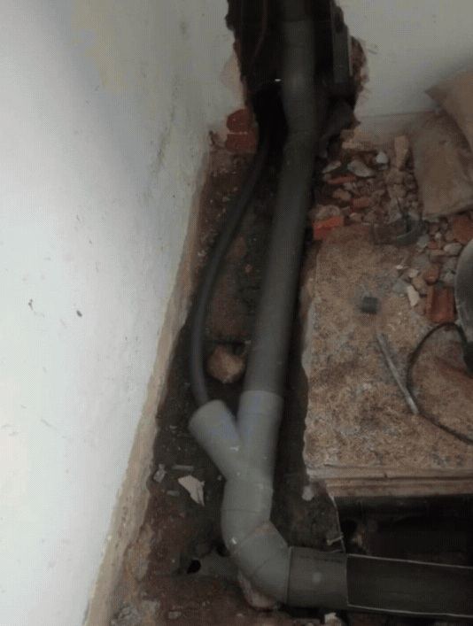 Tubería de desagüe de PVC con injerto en Y junto a la pared durante una reforma